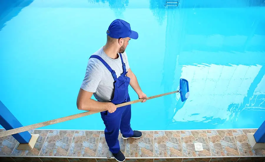man cleaning pool